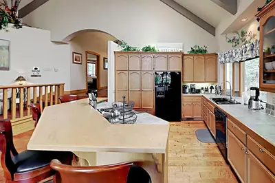 a kitchen with wooden cabinets and a large kitchen island at Emerald Oasis in Lake Arrowhead