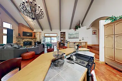 a kitchen with a stove and a living room at Emerald Oasis in Lake Arrowhead