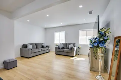 a living room with two couches and a vase of flowers at Home Between Los Angeles and Disney! Patio, Yard in Pico Rivera