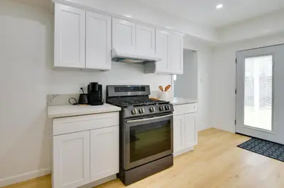 a kitchen with white cabinets and a stove at Home Between Los Angeles and Disney! Patio, Yard in Pico Rivera