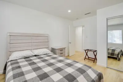 a bedroom with a bed with a checkered blanket at Home Between Los Angeles and Disney! Patio, Yard in Pico Rivera