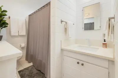 a white bathroom with a sink and a mirror at Quaint 1BD 1BA Bungalow in Los Angeles
