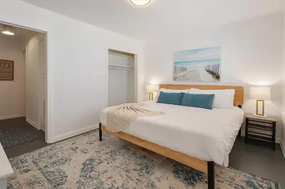 a bedroom with a large white bed with blue pillows at Quaint 1BD 1BA Bungalow in Los Angeles
