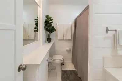 a white bathroom with a toilet and a sink at Quaint 1BD 1BA Bungalow in Los Angeles