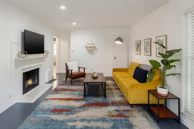 a living room with a yellow couch and a fireplace at Quaint 1BD 1BA Bungalow in Los Angeles