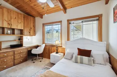 a bedroom with a bed and a desk and a chair at The Big Sky in Pearblossom