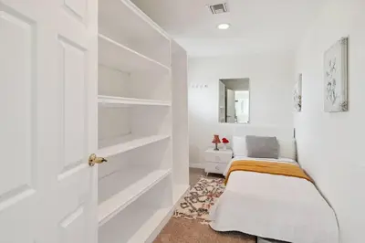 a bedroom with white walls and a closet with shelves at The Big Sky in Pearblossom