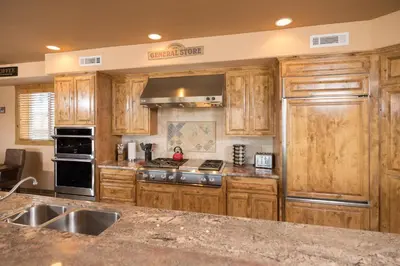a kitchen with wooden cabinets and a stove top oven at Big Bear Village View Haus is a large pet and kid friendly chalet with hot tub located a short walk to village in Big Bear Lake