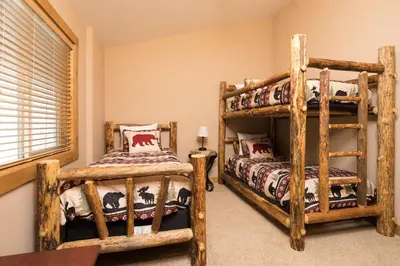 a bedroom with two bunk beds and a window at Big Bear Village View Haus is a large pet and kid friendly chalet with hot tub located a short walk to village in Big Bear Lake