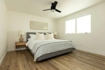 a white bedroom with a bed and a ceiling fan at 5609 East Seaside Walk in Long Beach