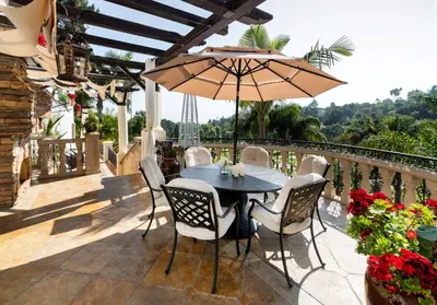 a patio with a table and chairs and an umbrella at Bel Air Luxury Villa 6 bedrooms entire house Los Angeles in Los Angeles