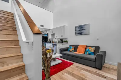 a living room with a couch and a kitchen at Cozy Oasis near Griffith Observatory in Los Angeles