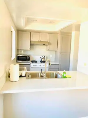 a white kitchen with a sink and a stove at Beautiful home near Disneyland. Entire place! in Orange