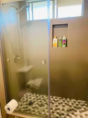 a shower with a glass door in a bathroom at Beautiful home near Disneyland. Entire place! in Orange