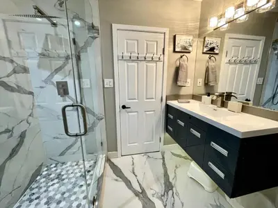 a bathroom with a shower and a sink and a glass door at Orchard Villa Disneyland 5 Bedroom Pool Home Spa in Anaheim
