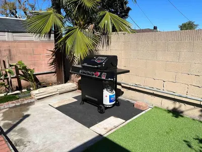a barbecue grill sitting in a yard next to a wall at Orchard Villa Disneyland 5 Bedroom Pool Home Spa in Anaheim