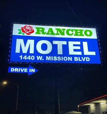a billboard sign for a motel in a gas station at Rancho Motel - Ontario Airport in Ontario