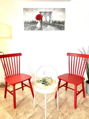 two red chairs and a table with a red umbrella at Cozy house near Disney, Knott’s & Beach!! in Fullerton