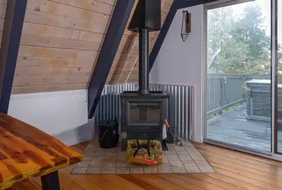 a fireplace in a room with a wooden floor at Hot Tub-EV-Kid Friendly-Arcade Game-BBQ-Fire Pit in Lake Arrowhead