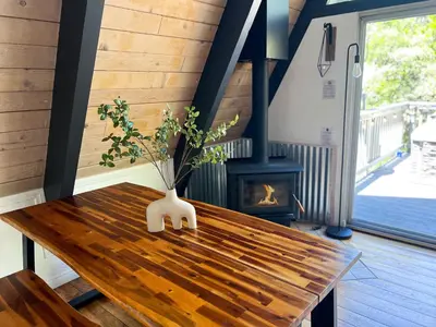 a wooden table with a vase with a plant on it at Hot Tub-EV-Kid Friendly-Arcade Game-BBQ-Fire Pit in Lake Arrowhead