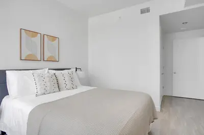 a white bedroom with a white bed with two paintings on the wall at Downtown 1BR w Pool Jacuzzi Gym nr 110 LAX-836 in Los Angeles