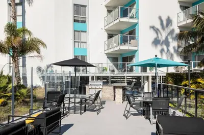 an outdoor patio with tables and chairs and umbrellas at Redondo Beach 1BR w Pool Gym WD nr Beach LAX-615 in Redondo Beach