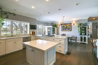 a large kitchen with white cabinets and a table at Stunning Home in Orange County with Stables! in Orange