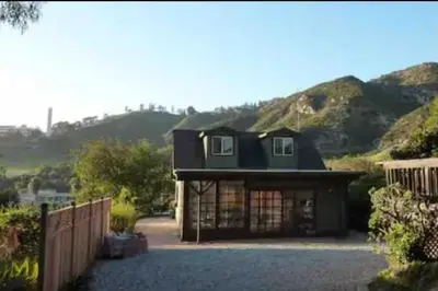 a small house with a mountain in the background at 30 PCT OFF! Malibu Serene Cottage with King Bed, Beach, BBQ in Malibu