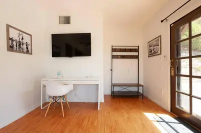 a room with a desk and a television on a wall at 30 PCT OFF! Malibu Serene Cottage with King Bed, Beach, BBQ in Malibu