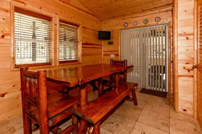 a dining room with a wooden table in a cabin at Circle Views by Big Bear Vacations Walk To Lake Boulder Bay Chalet in Big Bear Lake