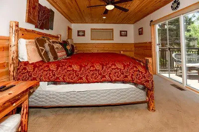 a bedroom with a bed in a room with a window at Circle Views by Big Bear Vacations Walk To Lake Boulder Bay Chalet in Big Bear Lake