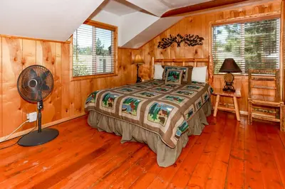 a bedroom with a bed and a fan in a room at Circle Views by Big Bear Vacations Walk To Lake Boulder Bay Chalet in Big Bear Lake