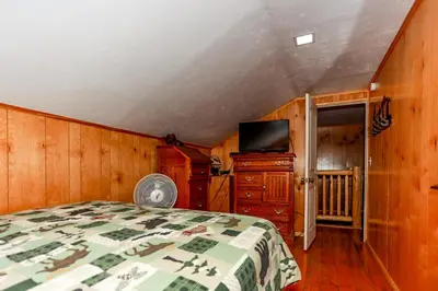 a bedroom with a bed and a flat screen tv at Circle Views by Big Bear Vacations Walk To Lake Boulder Bay Chalet in Big Bear Lake